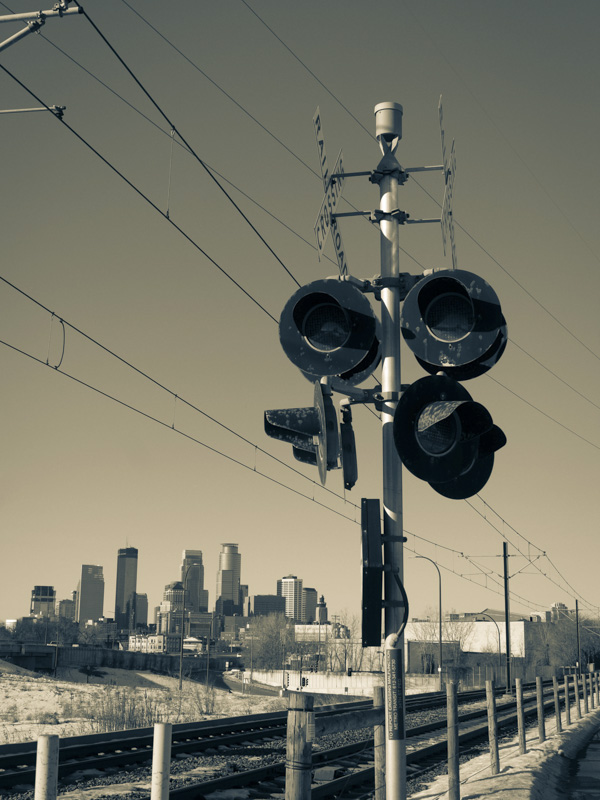 railroad crossing lights with Minneapolis skyline in the background 