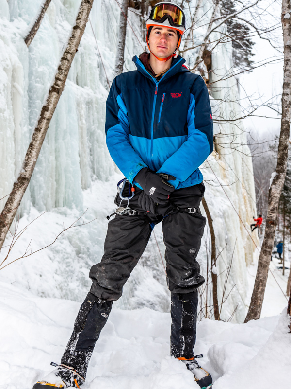 Portrait of a man in ice climbing gear stood in front of a wall of ice